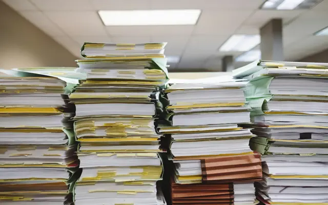 Stapel documenten en mappen op een bureau