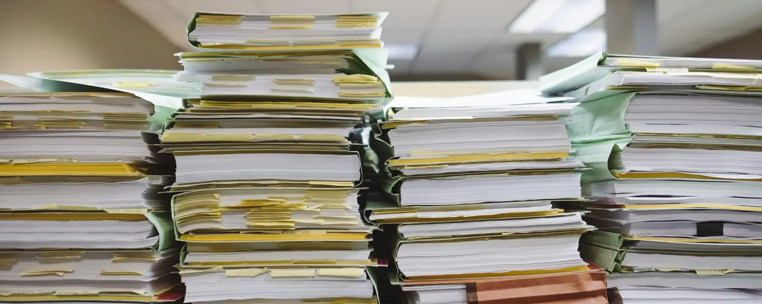Stapel documenten en mappen op een bureau