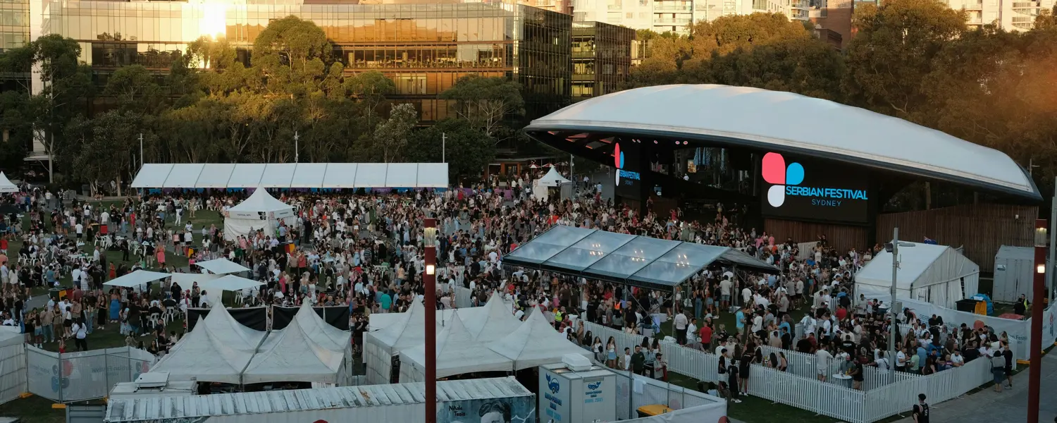 Bezoekers lopen in een rij naar de ingang van een druk festivalterrein