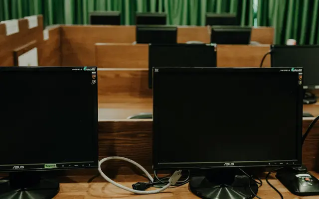 Een grote examenruimte met zwarte Asus computers die nog uitstaan 