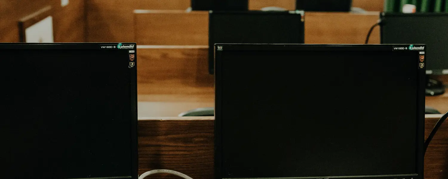 Een grote examenruimte met zwarte Asus computers die nog uitstaan 